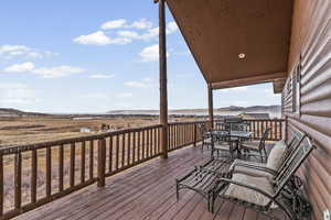 Wooden terrace featuring outdoor dining space and a mountain view