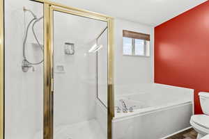 Full bath featuring a stall shower and a garden tub