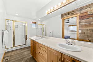 Full bath featuring ensuite bathroom, double vanity, healthy amount of natural light, dark wood-style flooring, and recessed lighting