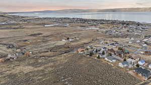 Aerial view of property and surrounding area featuring nearby suburban area and a water and mountain view
