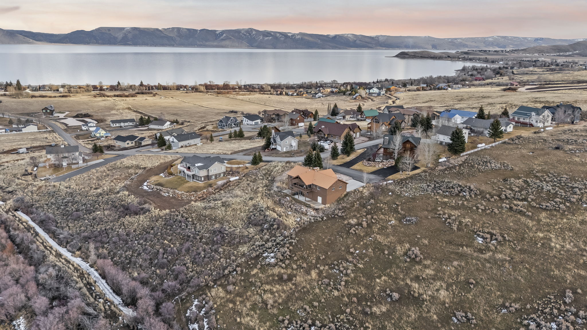 Aerial view at dusk of a residential view and a water and mountain view