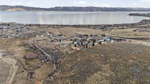 Aerial view of property and surrounding area featuring nearby suburban area and a water and mountain view