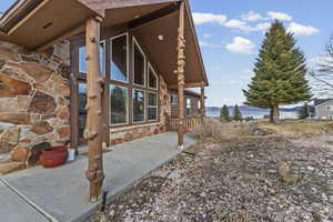 View of side of property with stone siding, a mountain view, and a patio