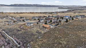 Aerial view of property and surrounding area featuring a water and mountain view and nearby suburban area