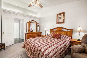 Primary bedroom with vaulted ceilings, Carpeted and a ceiling fan