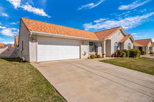 Mediterranean / spanish house featuring a front yard, stucco siding, a tile roof, and concrete driveway