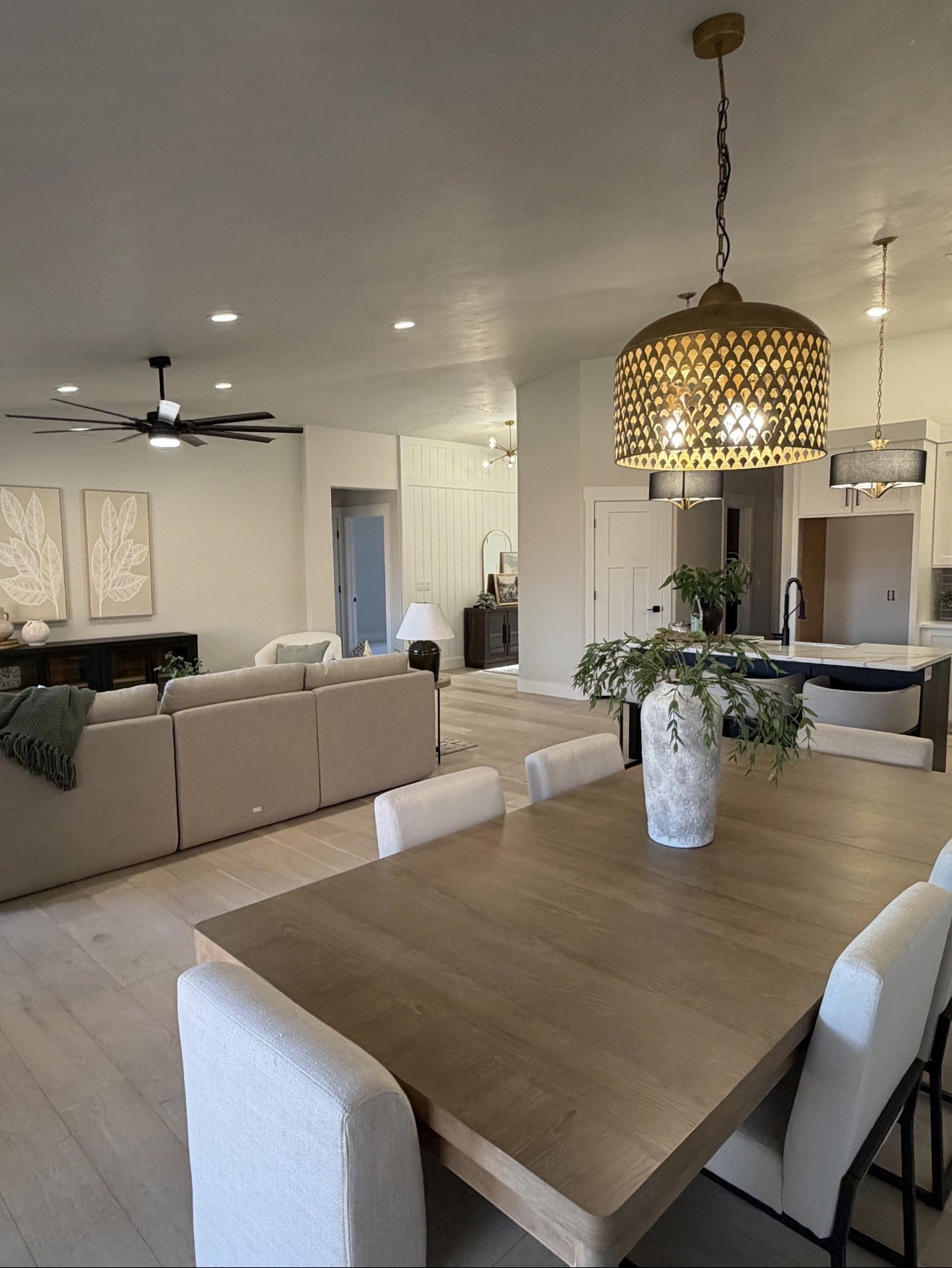 Dining area featuring a wood-finish table, upholstered chairs, and a decorative pendant light fixture