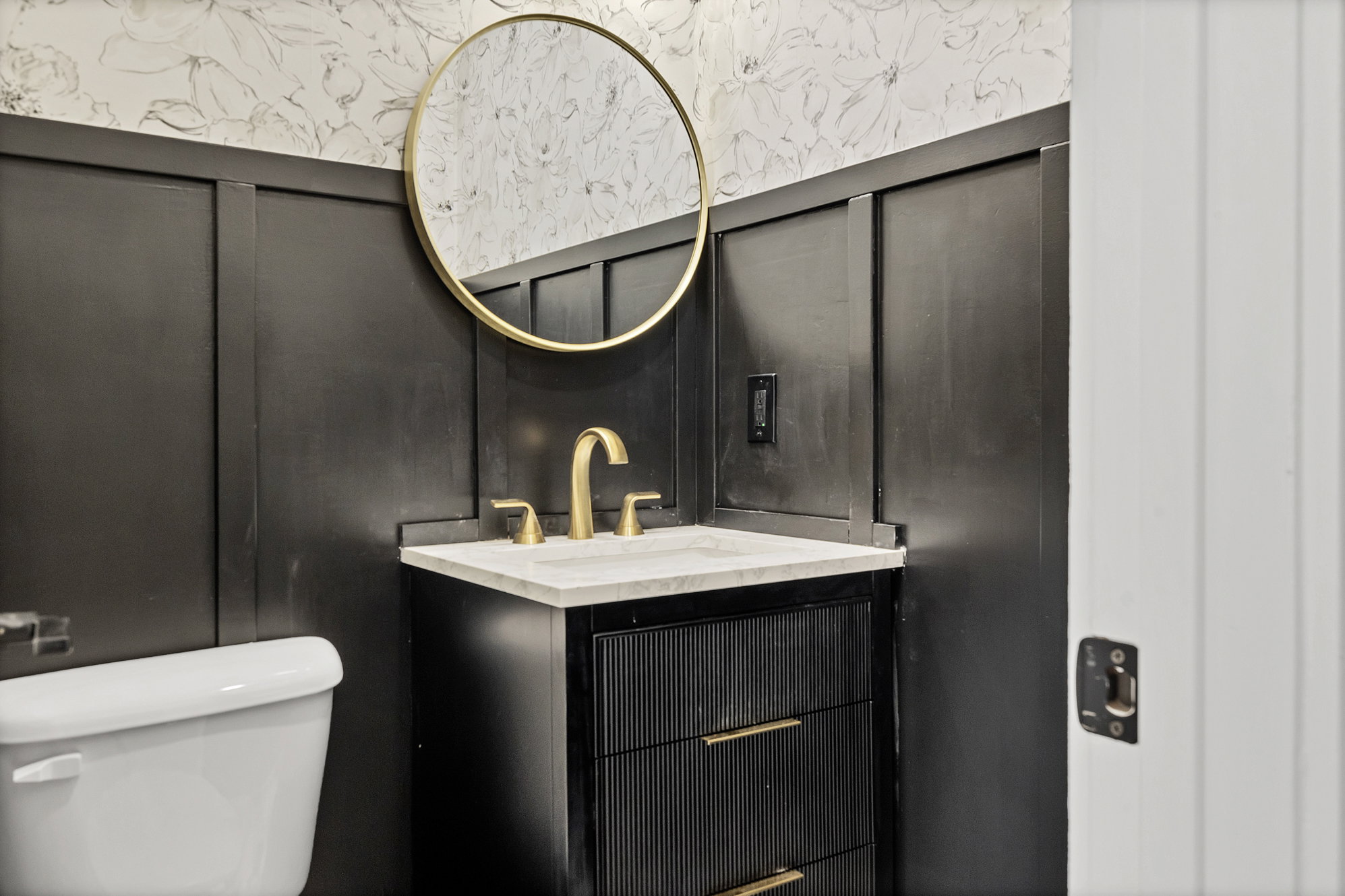 Half bathroom with vanity and wallpapered walls