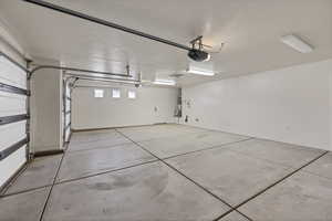 Garage featuring a garage door opener and baseboards