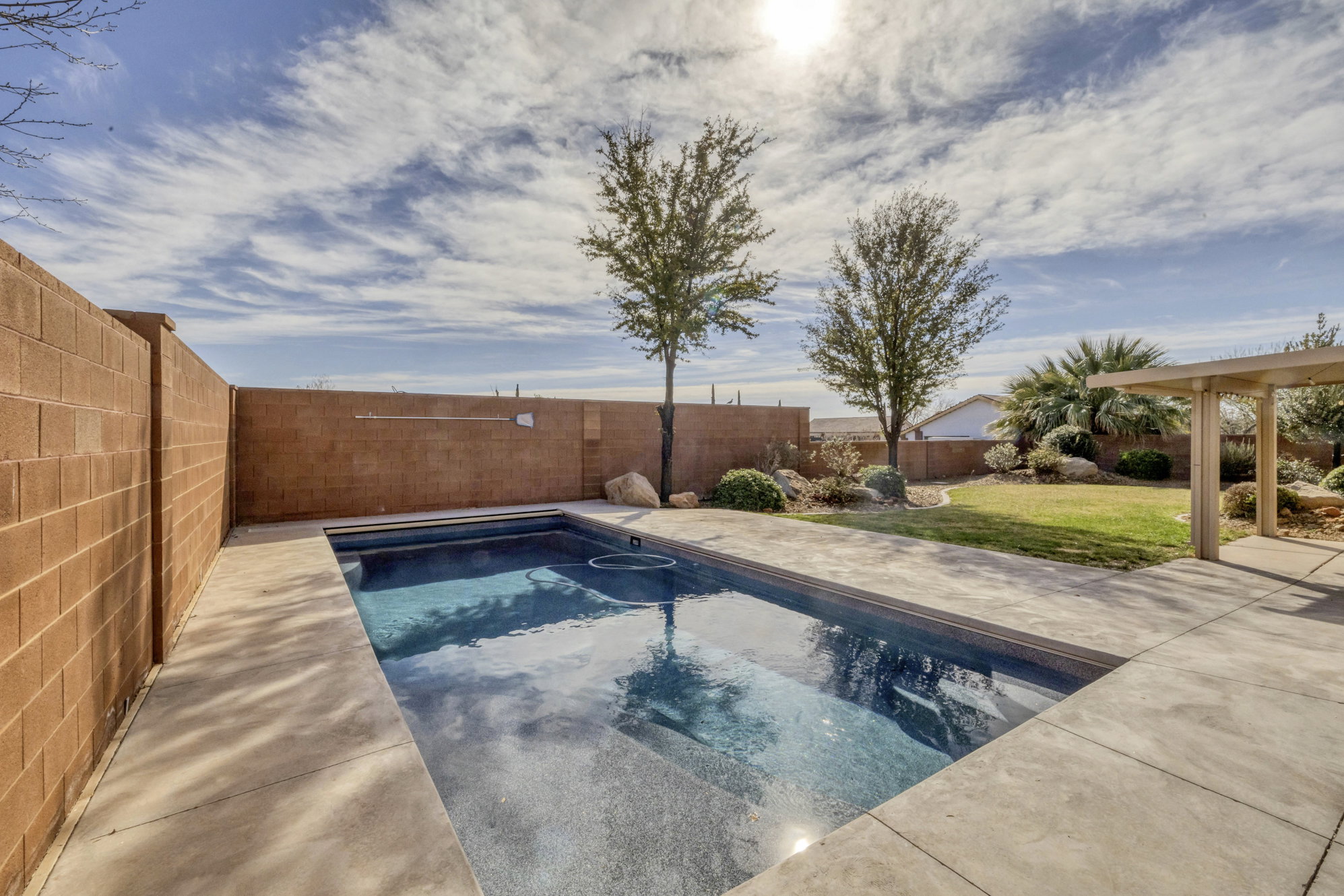 View of swimming pool with a fenced backyard and patio surround