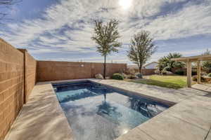 View of swimming pool with a fenced backyard and patio surround