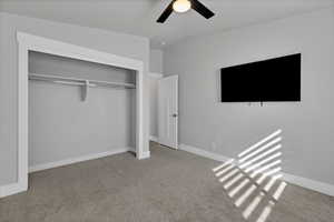 Unfurnished bedroom with light colored carpet, a closet, and ceiling fan