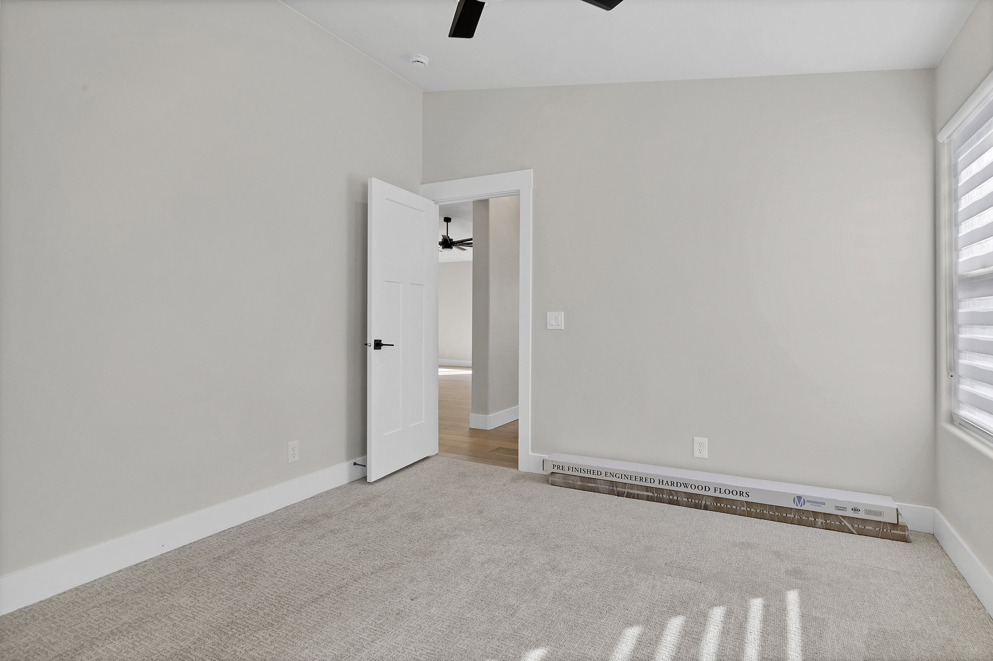 Unfurnished room with light carpet, a baseboard heating unit, and ceiling fan