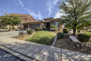 Mediterranean / spanish house with stucco siding, an attached garage, driveway, stone siding, and a tile roof