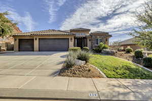 Mediterranean / spanish house featuring an attached garage, concrete driveway, stucco siding, and a tiled roof