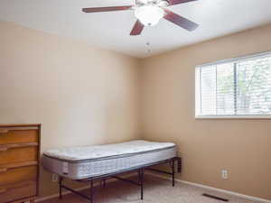 Bedroom featuring light colored carpet and a ceiling fan
