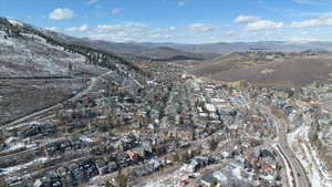 Aerial view of property's location with a mountain backdrop and nearby suburban area
