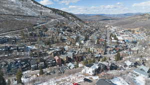 Snowy aerial view featuring a mountain view and a residential view