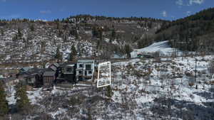 Snowy aerial view featuring a residential view and a mountain view