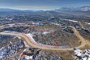 Aerial view of property's location featuring a mountain backdrop and property parcel outlined