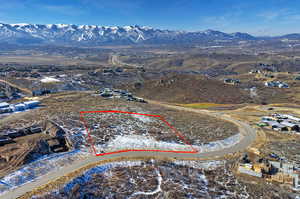 Aerial view of property and surrounding area with property parcel outlined and a mountainous background