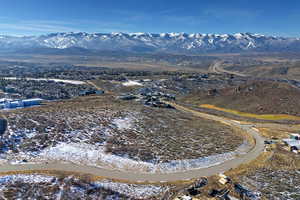 Aerial view of property and surrounding area with a mountain backdrop