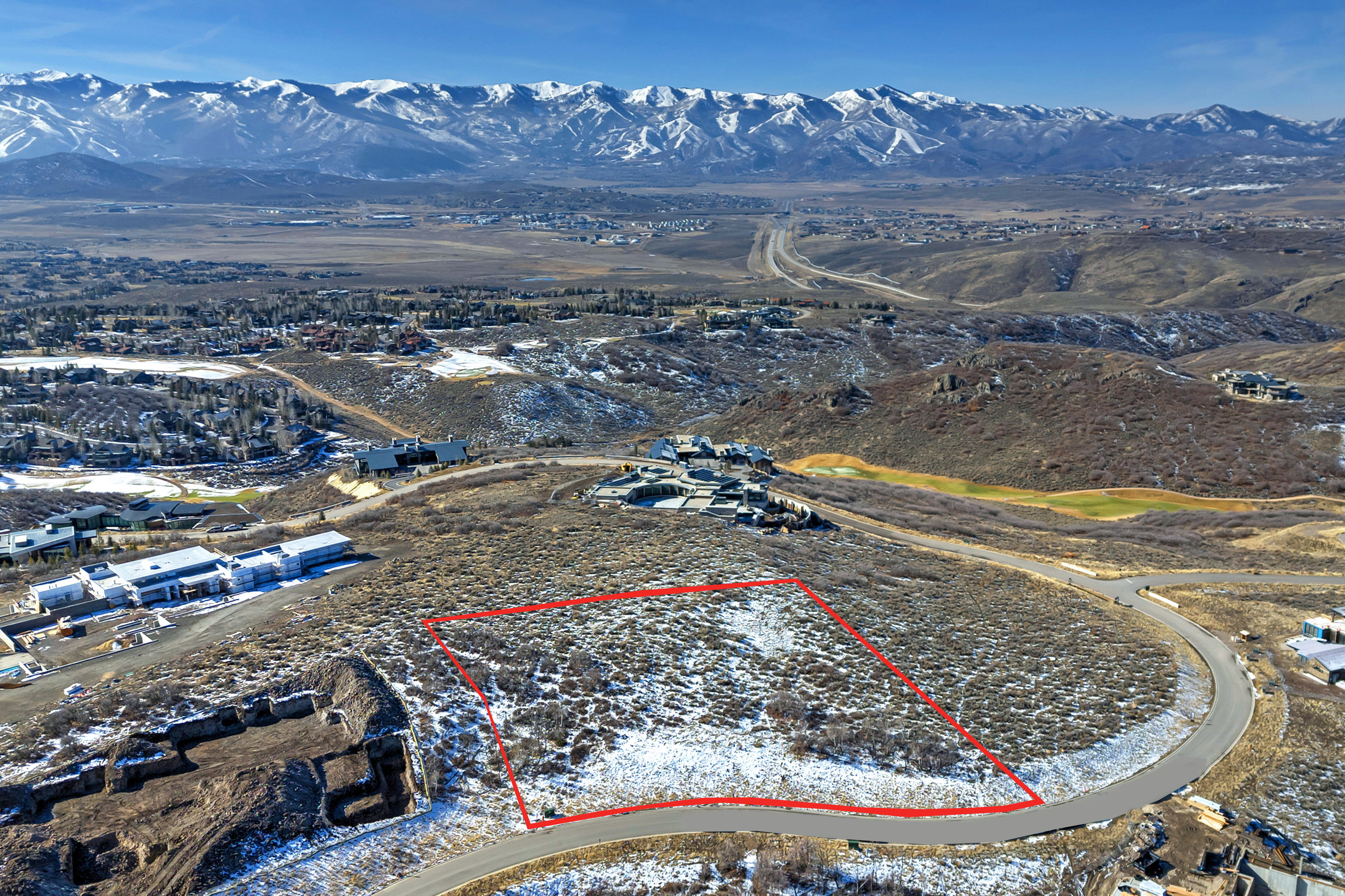 Aerial view of property's location featuring a mountainous background and property parcel outlined