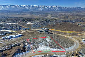 Aerial view of property's location featuring a mountainous background and property parcel outlined