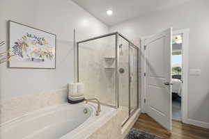 Ensuite bathroom featuring a marble finish shower, a textured ceiling, a garden tub, and wood finished floors