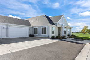 View of front of home featuring a shingled roof, an attached garage, concrete driveway, and board and batten siding