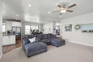 Living room with recessed lighting, a ceiling fan, a textured ceiling, and carpet