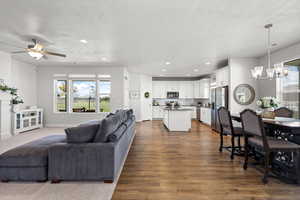 Living area with a chandelier, wood-type flooring, ceiling fan, and a textured ceiling