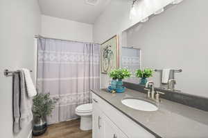 Full bath featuring vanity, wood style finished floors, and a textured ceiling