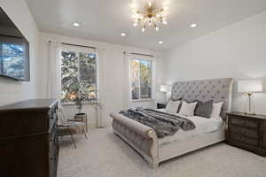 Bedroom featuring light carpet and hanging lights