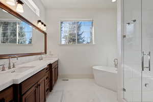 Bathroom with a soaking tub, a stall shower, double vanity, and light tile patterned flooring