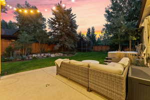Patio terrace at dusk featuring a trampoline, a patio, a fenced backyard, and an outdoor lounge area