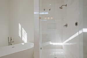 Bathroom featuring a freestanding tub, a stall shower, and healthy amount of natural light