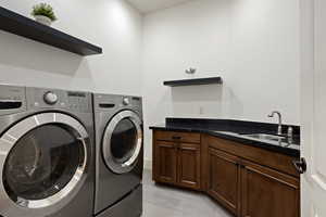 Laundry room with washing machine and clothes dryer, cabinet space, and light tile patterned flooring