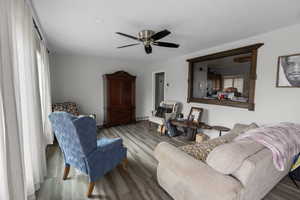 Living area with wood finished floors, a ceiling fan, and plenty of natural light