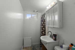 Bathroom with a shower with shower curtain, vanity, and light wood-style flooring