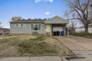 Ranch-style house with concrete driveway, a garage, entry steps, and a front yard