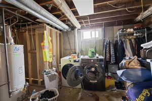 Basement featuring water heater and washer and dryer