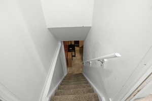 Stairs featuring baseboards and concrete flooring