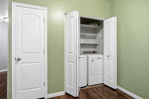 Laundry area featuring baseboards and dark wood-type flooring