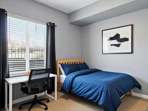 Bedroom with light carpet, an office area, and a ceiling fan