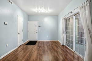 Entrance foyer with dark wood-style flooring and baseboards
