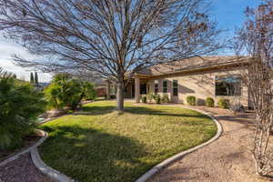 Back of property with stucco siding and a yard
