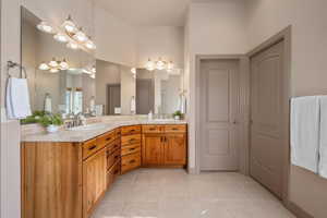 Bathroom with double vanity and light tile patterned floors