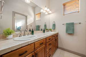 Bathroom featuring double vanity and light tile patterned floors