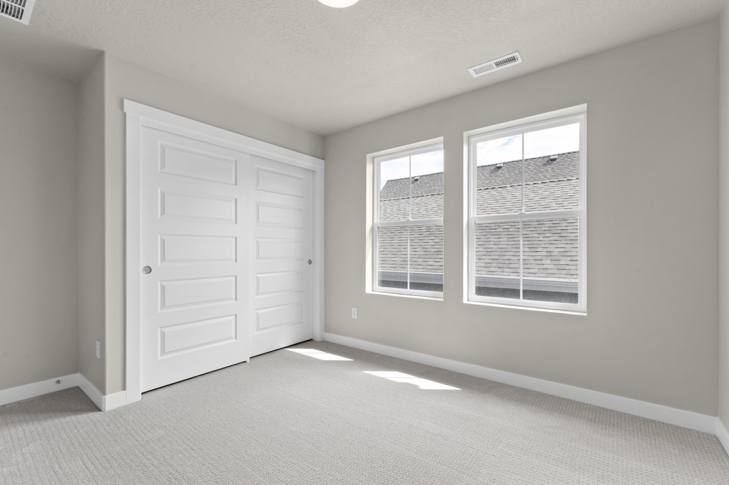 Unfurnished bedroom featuring light colored carpet, a closet, and a textured ceiling